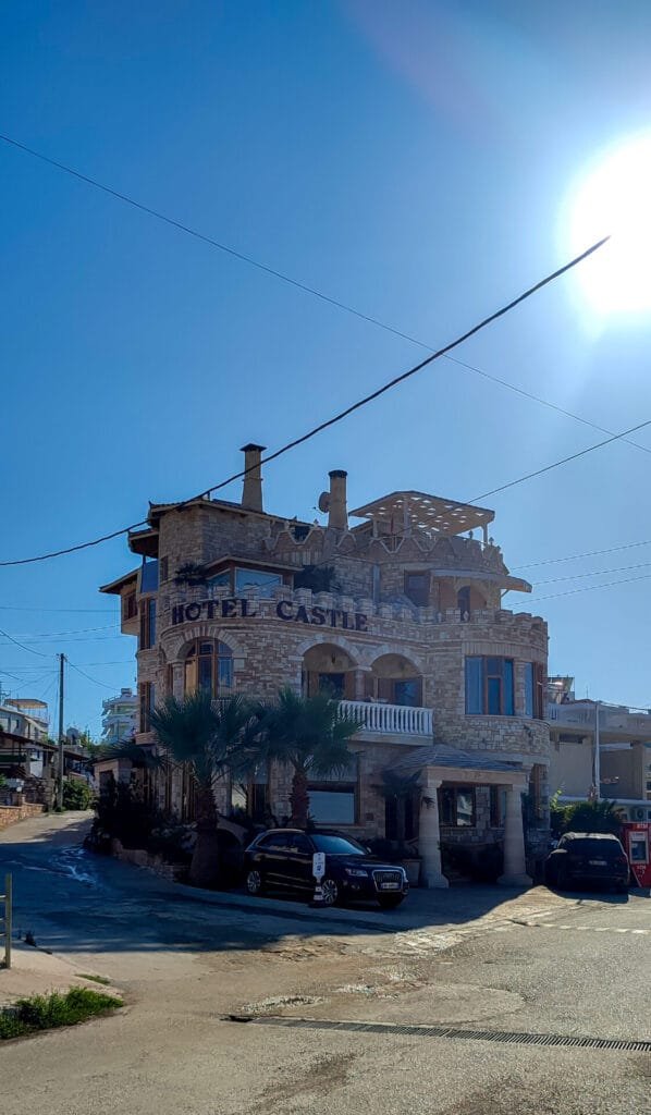 Stone building with 'Hotel Castle' signage in Sarandë, Albania, under a clear blue sky