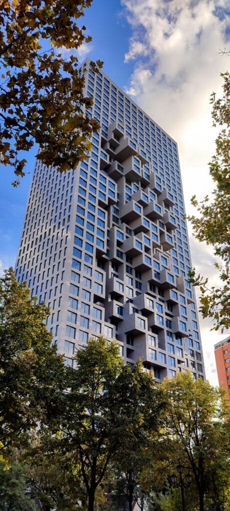 High-rise building with unique architectural design surrounded by trees