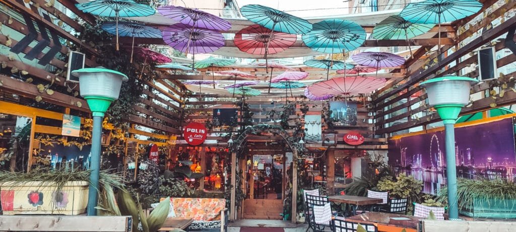 Colorful bar entrance with vibrant decorations hanging from the ceiling