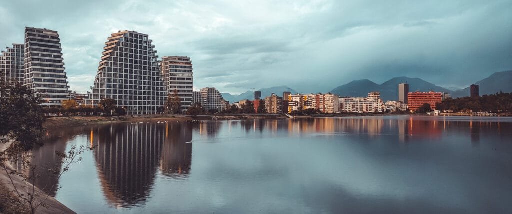 Calm lake with modern buildings reflecting in water